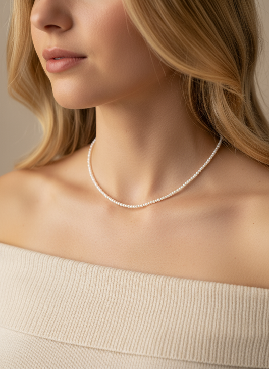 Blonde model wearing delicate seed pearl necklace